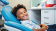 © Elena - Smiling African American boy sitting in dentist's chair, kids teeth care, pediatric dentistry office for children, happy child ready for teeth checkup, first dental visit to pedodontist