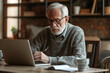 © AI_images - Senior man in glasses looking at laptop computer screen.