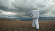 An astronaut explores an unknown planet. Heavy cloudy sky.