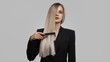Beautiful woman combing her hair on a gray background.