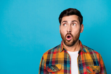 Sticker - Photo of stunned astonished man with beard dressed checkered shirt staring at proposition empty space isolated on blue color background