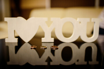Wall Mural - Wedding rings and the inscription I love you on table