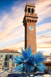 Murano's clock tower, with Comet Star in blue at its foot. The glass artwork in the vicinity of the Murano Clock Tower, Torre dell'Orologio.