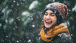Woman laughing joyfully in snow, wearing scarf around her neck. Perfect for winter-themed projects or holiday greetings