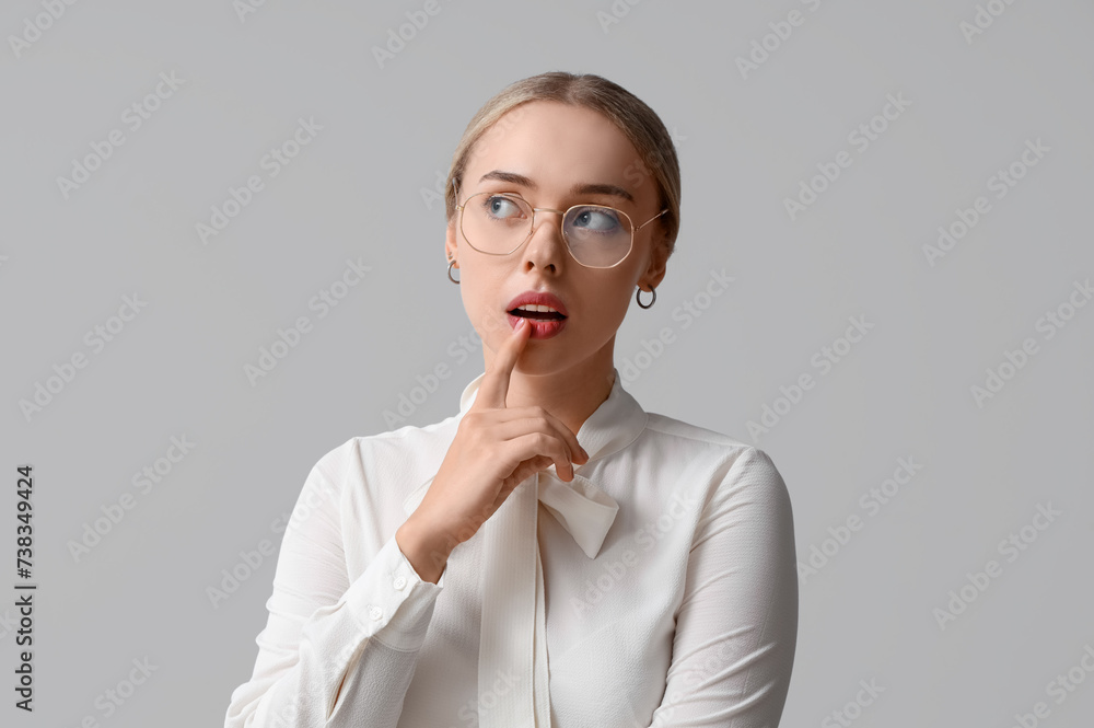 Thoughtful young woman on light background