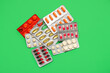 canvas print picture - Blister packs with different pills on green background