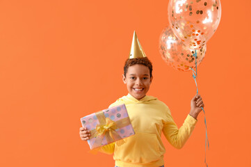 Poster - Little African-American boy in party hat with Birthday gift and balloons on orange background