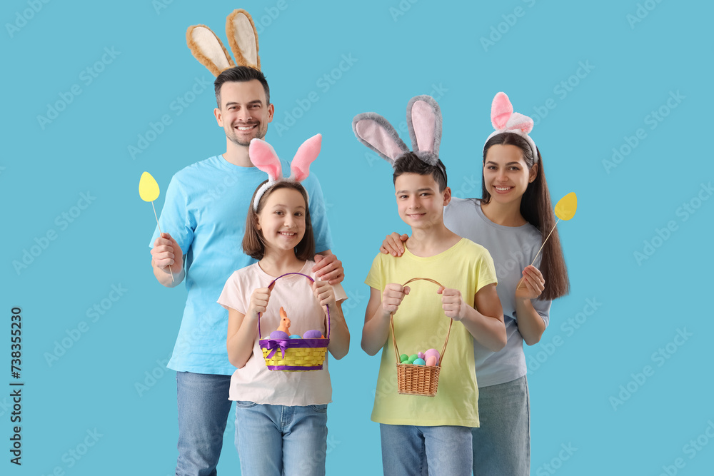 Happy family in bunny ears with Easter eggs on blue background