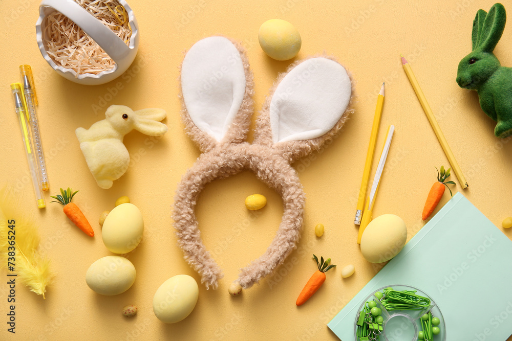 Bunny ears with Easter eggs and school supplies on yellow background