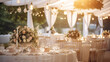 Zastawa stołowa na przyjęciu weselnym lub urodzinach i chrzcinach - dekoracja stołu weselnego w ogrodzie przez florystę i dekoratora. Piękne bukiety kwiatów na stoliku