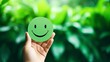© Nia™ - Hand holding green paper cut happy smile face on green background , positive thinking, mental health assessment , world mental health day concept - generative ai