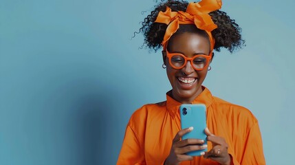 Isolated shot of positive smiling woman holds modern cellular enjoys wireless internet checks bank account or sends message in social networks wears orange clothes models over blue bac : Generative AI