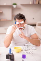 Wall Mural - Young man shaving face at home