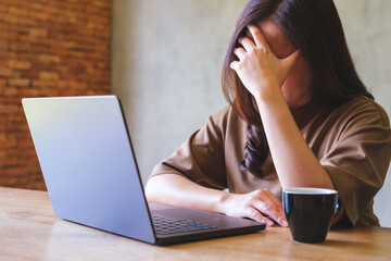 Canvas Print - A woman get headache and stressed while working online on laptop computer at home