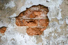 Old Plaster Wall Was Cracked Until The Red Bricks Were Visible Inside, Inferior Construction Quality.