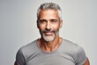 Handsome mature man in grey t-shirt on grey background