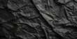 A black rolled paper texture with wrinkles, captured in a matte photo, appearing crumpled.
