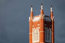 Close Up View Of A Tall Historic Church Steeple Against A Dark Sky
