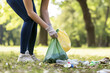 People participating in a park cleanup, collecting rubbish, promoting individual actions toward environmental conservation