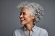 Portrait of happy senior businesswoman with grey hair smiling at camera
