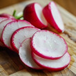 © AIRina - Sliced radishes on a wooden cutting board, ready for a fresh salad, close-up view