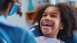 Smiling mixed race girl in a dental clinic for children. Child with a toothy smile during inspection of oral cavity by a dentist. Close-up