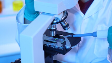 scientists are doing research in a science lab. a medical chemist in a white coat, gloves and goggle