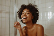 Dental hygiene scene of a happy black afro woman brushing her teeth in the morning with toothbrush, in bathroom with copy space on white wall tiles