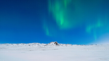 Wall Mural - Aurora Borealis. Northern Lights over the mountains. A winter night landscape with bright lights in the sky. Landscape in the north in winter time. A popular place to travel.