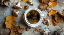 A Cup Of Coffee Surrounded By Mushrooms And Leaves. Perfect For Nature-themed Designs And Cozy Autumn Vibes
