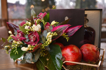 floral arrangement with orchids and pomegranates.