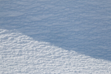 Wall Mural - diagonal shadow on textured white snow abstract winter background