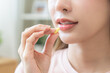 © KMPZZZ - Dietary supplement, healthy diet positive asian young woman hand holding pill capsule, take vitamin in mouth for beauty skin hair, taking medicine with glass of water at home, pharmacy and health care