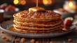 A stack of fluffy pancakes served with a generous drizzle of maple syrup, topped with a pat of mel