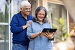 © G-images - Senior couple using a digital tablet together in their backyard