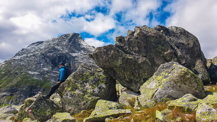 Poster - Hiker man standing in front of massive rock formation with panoramic view of majestic mountain ridge in High Tauern National Park, Carinthia, Austria. Idyllic hiking trail in Austrian Alps. Wanderlust