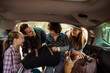 © Davor - Family road trip packing car trunk with smiling children and parents