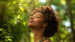 © EmmaStock - relaxed Black American woman breathing fresh air in a green forest