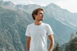 Ein Mann in einem weißen T-shirt vor einer schönen Berglandschaft, T-shirt Mockup 