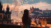 A graceful lady standing watching fireworks show with a view of historic buildings in the city of Prague, Czech Republic in Europe.