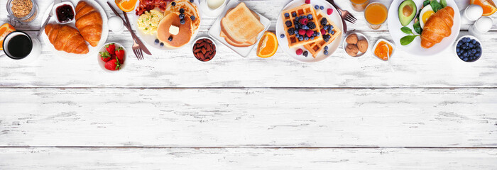 Wall Mural - Breakfast or brunch top border on a white wood banner background. Above view. Selection of sweet and savory food items.