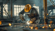 © MP Studio - worker in protective gear using a welding tool on metal, with sparks flying around in an industrial setting.