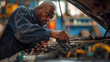 mechanic deeply focused on his work, inspecting or repairing a vehicle in an auto repair shop.