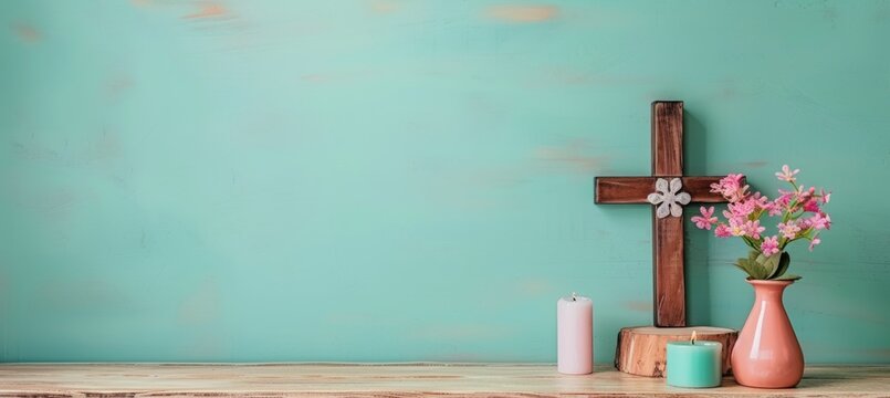Christian cross and candles on wooden floor, isolated on pastel background with text space