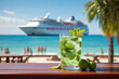 Glass of mojito stands on table on sunny beach with ocean cruise liner on background