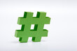 green paper hashtag symbol on white background