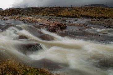 Wall Mural - Slow shutter release of a fast flowing river in the highlands of Scotland