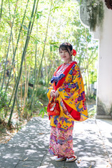 沖縄県那覇市の中国庭園で琉装を着た２０代の若い日本人女性 A young Japanese woman in her 20s wearing Ryuso in a Chinese garden in Naha City, Okinawa Prefecture