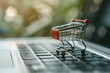 Online shopping concept visualized with a miniature shopping cart on a laptop keyboard Illustrating the ease and accessibility of e-commerce transactions.