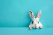 Easter bunny peeking out from a vibrant blue background Cute and playful holiday concept Space for text
